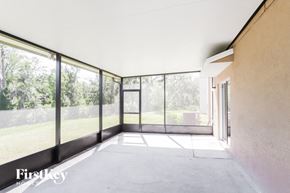 Wimauma house for rent - a living room with large glass windows and a concrete floor