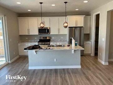 Commerce City house for rent - a kitchen with white cabinets and a counter top