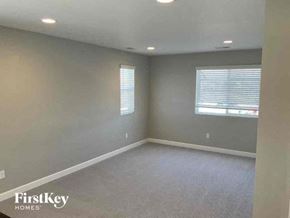 Commerce City house for rent - an empty living room with a window and gray walls