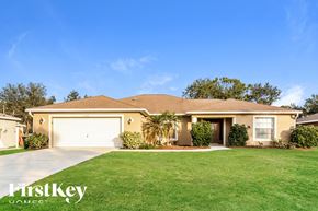 North Port house for rent - a beige house with a lawn and a garage