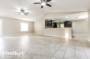 North Port house for rent - an empty living room with a kitchen and ceiling fans
