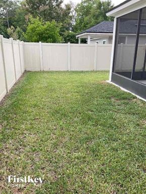 Jacksonville house for rent - a backyard with a white fence and a grassy yard