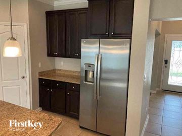 Jacksonville house for rent - a kitchen with a stainless steel refrigerator and cabinets