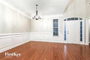 Fayetteville house for rent - A room with wooden floors and a chandelier hanging from the ceiling.