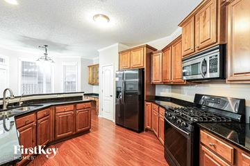 Fayetteville house for rent - A kitchen with wooden cabinets and black appliances.