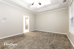 Fayetteville house for rent - A spacious room with a carpeted floor and a ceiling fan.