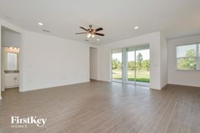 Howey In The Hills house for rent - A spacious room with a ceiling fan and sliding glass doors.