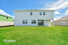 Howey In The Hills house for rent - A white house with a green building to the left and a blue sky in the background.