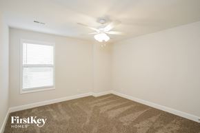 Clarksville house for rent - a bedroom with a ceiling fan and a window