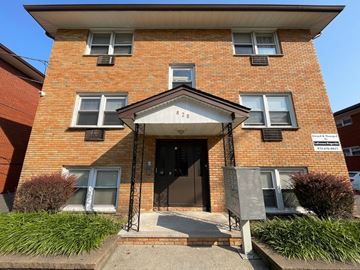 Irvington apartment for rent - A red brick building with a black door and a small porch.