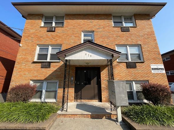 Irvington apartment for rent - A red brick building with a black door and a small porch.