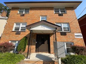 Irvington apartment for rent - A red brick house with a black door and a small porch.