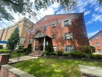 East Orange apartment for rent - A red brick building with a black iron fence in front.