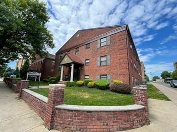 East Orange apartment for rent - A red brick building with a green lawn in front.
