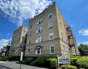 East Orange apartment for rent - A tall apartment building with a sign in front that says "Ashland Ave.".