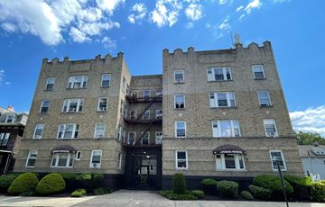 East Orange apartment for rent - A large stone building with a balcony on the second floor.