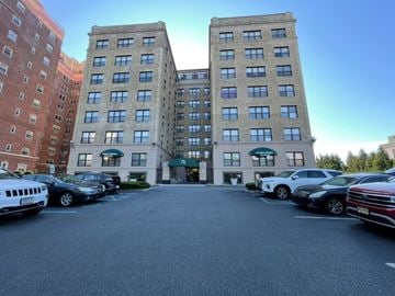 East Orange apartment for rent - A parking lot in front of a multi-story building with cars parked.