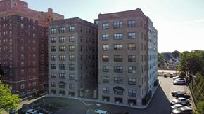 East Orange apartment for rent - A large building with a parking lot in front of it.