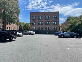 East Orange apartment for rent - A parking lot with cars and a building in the background.