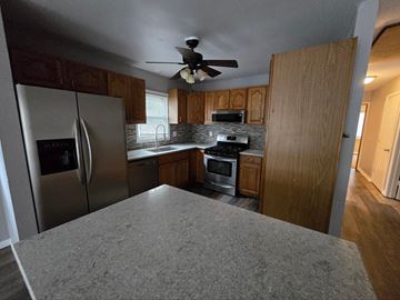 Lake Station house for rent - a kitchen with stainless steel appliances and wooden cabinets