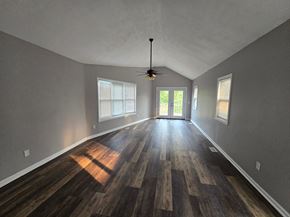 Lake Station house for rent - an empty living room with wood floors and a ceiling fan