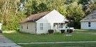 Warren house for rent - A white house with a brown roof is surrounded by green grass.