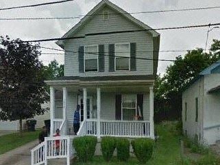 Warren house for rent - A white house with a porch and a person sitting on it.