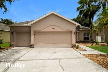 Riverview house for rent - a beige house with a garage door and a driveway