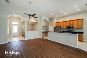 Riverview house for rent - an empty living room with a kitchen and a ceiling fan