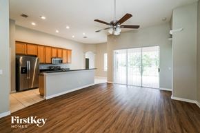 Riverview house for rent - an empty living room with a kitchen and a ceiling fan