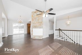 Lewisville house for rent - an empty living room with a ceiling fan and a staircase