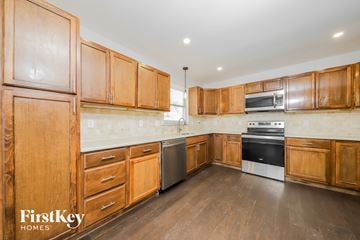 Lewisville house for rent - a kitchen with wooden cabinets and stainless steel appliances