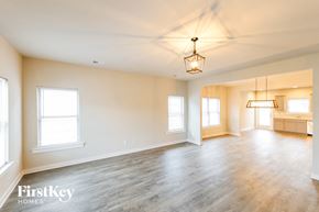 Cullman house for rent - A spacious room with wooden floors and a hanging light fixture.