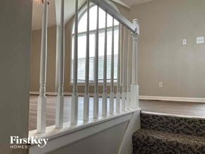 Kearney house for rent - A staircase with a carpeted runner and white balusters leads to a window.