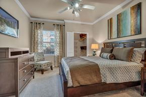 Dallas apartment for rent - a bedroom with a bed and a ceiling fan