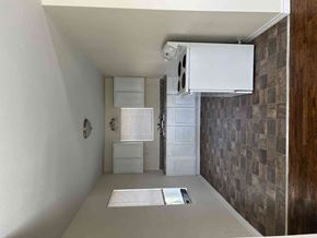Gainesville house for rent - A white fridge and freezer are in a room with a brown tiled wall.