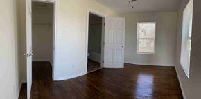 Gainesville house for rent - A room with a white door and a window with blinds.