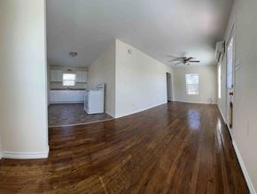 Gainesville house for rent - A room with wooden floors and a ceiling fan.