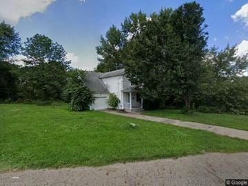 Warren house for rent - A white house with a grey roof is surrounded by a green lawn.