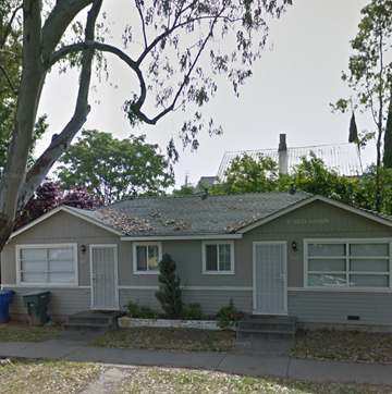 Sacramento apartment for rent - A house with a grey roof and white windows is surrounded by trees.