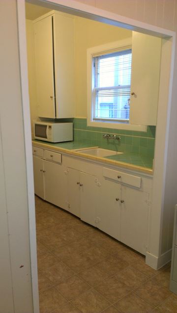 Oakland apartment for rent - a kitchen with white cabinets and a sink and a window