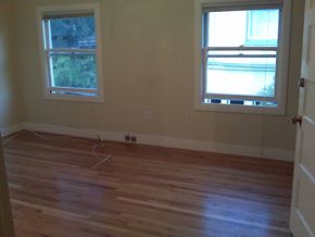Oakland apartment for rent - an empty living room with wooden floors and two windows