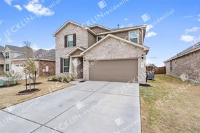 Hutto house for rent - A large, modern house with a garage is surrounded by a well-maintained lawn.