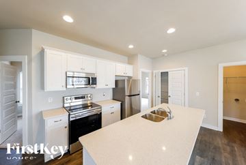 Cullman house for rent - A kitchen with a white counter top and stainless steel appliances.