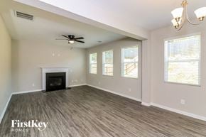 Dallas house for rent - an empty living room with a fireplace and a ceiling fan