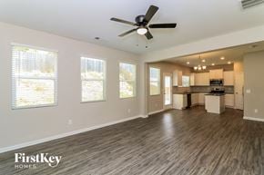 Dallas house for rent - an empty living room with a ceiling fan and a kitchen