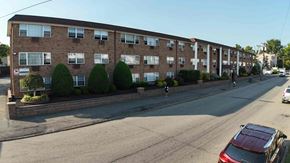 Irvington apartment for rent - A street view of a residential area with apartment buildings and parked cars.