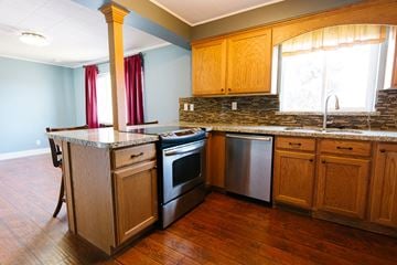 Murray house for rent - a kitchen with wooden cabinets and stainless steel appliances