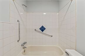 Philadelphia apartment for rent - A white tiled bathroom with a bathtub and a toilet.
