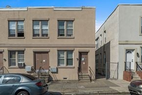 Philadelphia apartment for rent - A grey car is parked in front of a brown building.